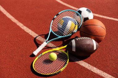 Set of sport equipment, rackets and tennis balls soccer and basketball balls.