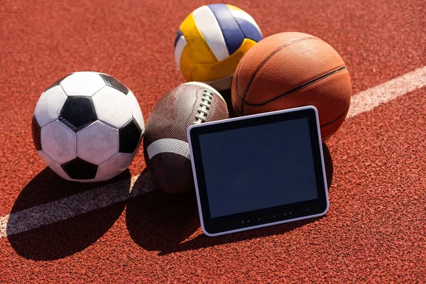Tablet computer and balls. Concept of sports bet.