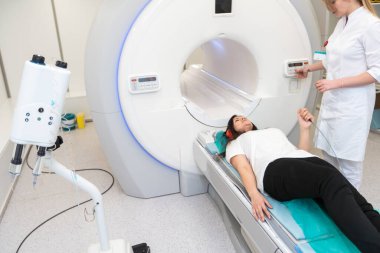 Modern hastane laboratuvarında bir hastaya tıbbi tomografi ya da MRI taraması yapın. Radyografi bölümünün içi. Beyaz odada teknolojik olarak gelişmiş ekipmanlar var. Manyetik rezonans tanılama makinesi.