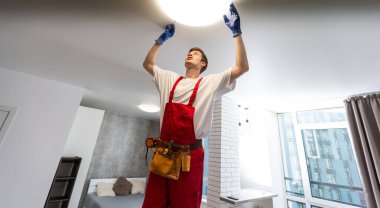 İşçi evin tavanına lamba yerleştiriyor