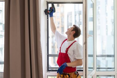 a repairman repairs, adjusts or installs metal-plastic windows in the apartment. glazing of balconies, loggias, verandas in house. production of double-glazed windows to individual sizes.