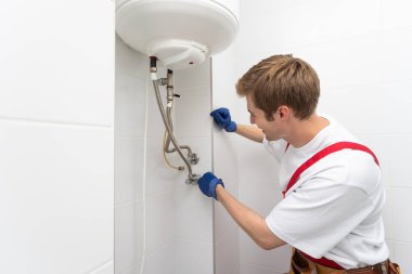 Professional engineer doing a boiler inspection at home.