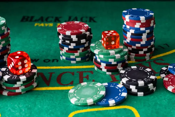 Stack of green, red, blue, white and black Playing Poker Chips in a green background. High quality photo