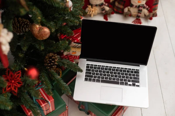 laptop and Christmas tree in the background.