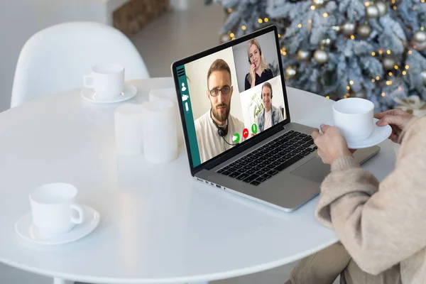 People on virtual call with family and friends exchanging gifts and celebrating virtual christmas online due to social distancing and coronavirus lockdown and quarantines. Image on computer screen