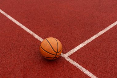 Spor salonunun kahverengi sahasında turuncu basketbol. Sokak basketbolu kavramı. Yüksek kalite fotoğraf