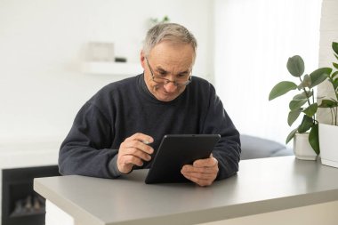 Komuta sizde dijital tablet haber okuma gülümseyerek. Evde, taşınabilir bilgisayarla neşeli heyecan olgun erkek kopya alanı