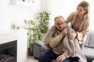 Genç fizyoterapistle rehabilitasyon işlemine katılan yaşlı bir erkek emeklinin başından vurulmuş. Yürüme engelli emekli bir adam profesyonel yardıma minnettar.