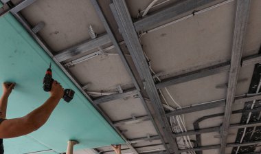 Adam alçı tavanlar için metal çerçeve monte ediyor. Yüksek kalite fotoğraf