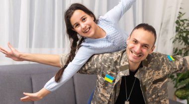 Ukrayna askeri üniformalı babası ve kızı. Aile toplantısı.