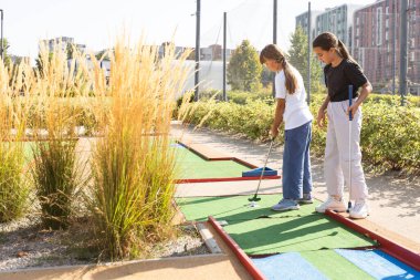 Golf sahasında golf sopaları tutan sıradan çocuklar. Gün batımı. Yüksek kalite fotoğraf