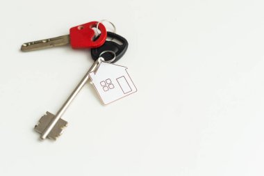 Ev sembollü anahtarlık ve beyaz arka planda anahtarlık, emlak konsepti. Yüksek kalite fotoğraf