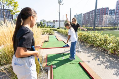 Golf sahasında golf sopaları tutan sıradan çocuklar. Gün batımı. Yüksek kalite fotoğraf