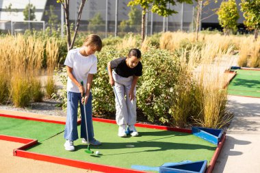 Golf sahasında golf sopaları tutan sıradan çocuklar. Gün batımı. Yüksek kalite fotoğraf