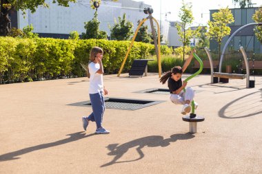 İki çocuk atlıkarıncada didişiyor ve yüksek sesle gülüyor, takılıyor, oyun alanında eğleniyor. Mutlu aktiviteler. Yüksek kalite fotoğraf