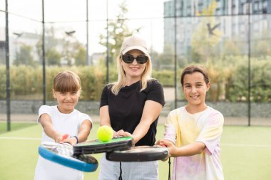 Güneşli bir günde Padel oynayan çocuklu genç bir kadın. Yüksek kalite fotoğraf