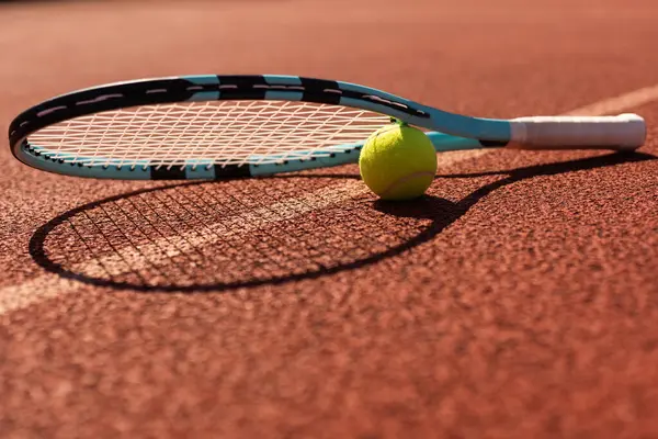 Play tennis. Close-up of tennis racket and tennis ball laying on the court . High quality photo