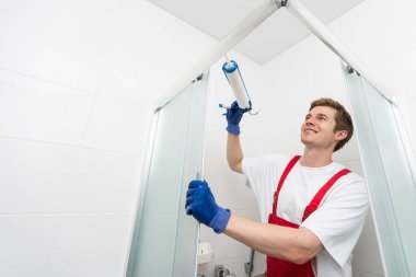 Tesisatçı silikon kartuş duş kabinin alüminyum çıta sabitleme kullanarak.