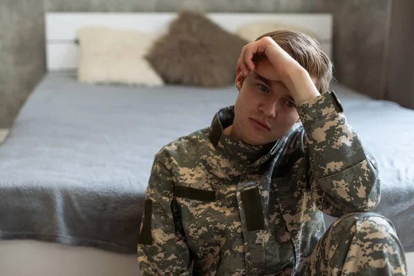 Thoughtful young handsome soldier in military uniform