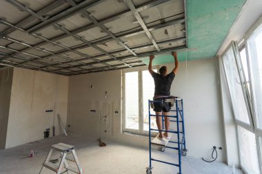 Yeni dairenin tavanında iki işçi var. Yüksek kalite fotoğraf