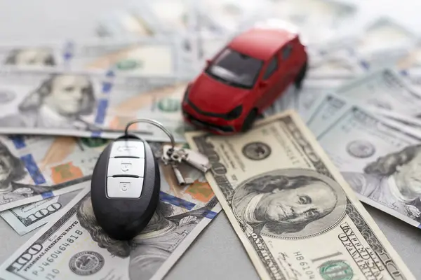 small toy car with real car keys lying dollar cash. Expensive gift. Sell or rent concept. High quality photo