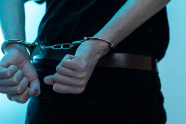 Elleri kelepçeli, siyah arka planda bir erkek. Yüksek kalite fotoğraf