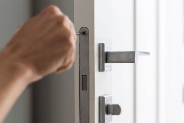 Çilingir marangoz, ev hizmeti tazminatı için beyaz kapı tokmağını tornavidayla tamir etti. Yüksek kalite fotoğraf