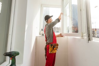 Hizmetçi içeride kurulum için pencereyi ölçüyor. Mesaj için yer var. Yüksek kalite fotoğraf