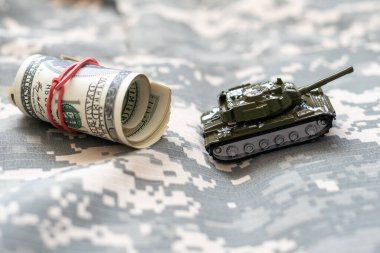 Dolar banknotlarının arka planında oyuncak tankı var. Yüksek kalite fotoğraf
