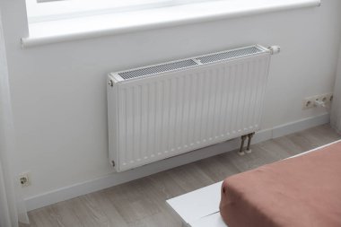 Radyatörlü beyaz ısıtıcı ve bir apartmanın duvarında modern bir termostat. Yüksek kalite fotoğraf