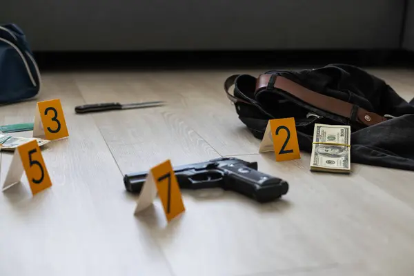 High contrast image of a crime scene with gun and markers on the floor. High quality photo