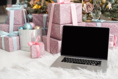Hediyeli dizüstü bilgisayar, arkada Noel ağacı..