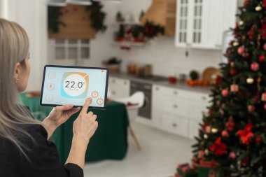 Evdeki kadın akıllı ekran, otomasyon iç sistemi kullanıyor.