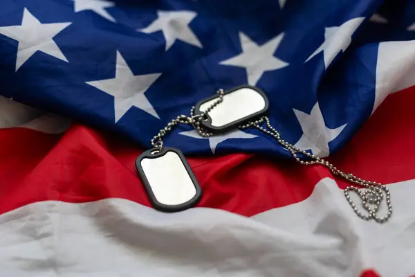 Veterans Day USA flag with dog tags on rustic red wood background, closeup. . High quality photo