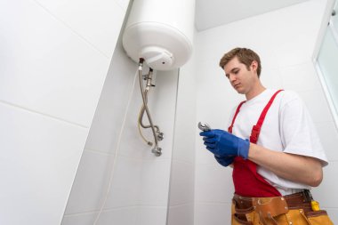 Professional engineer doing a boiler inspection at home.