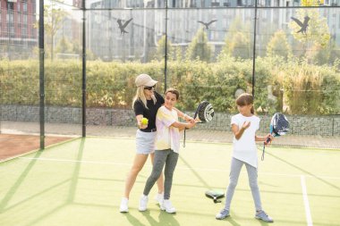 Güneşli bir günde Padel oynayan çocuklu genç bir kadın. Yüksek kalite fotoğraf