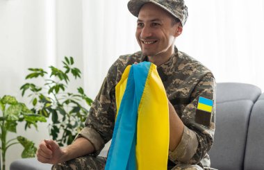 Ukraynalı bir asker, ulusal bayrağı güçlü bir sembolün sembolü olarak elinde tutuyor. Ukrayna 'da Savaş