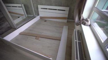 Mobilya derleyicisi yatak çerçevesini monte eder, kendin yap ve yeni mobilyalar monte et..