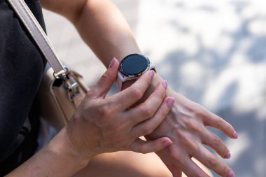 Kadın eli şık giyiniyor, aktif yaşam tarzını kontrol ediyor ve dışarıda plajda spor aleti kullanıyor. Yüksek kalite fotoğraf