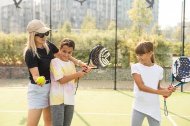 Anne ve kızları dışarıda Padel oynuyorlar. Yüksek kalite fotoğraf