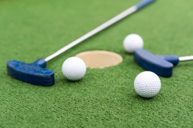 Çeşitli minyatür golf sopaları ve toplar sentetik çimlere çarpar. Yüksek kalite fotoğraf