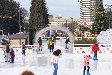 KYIV, UKRAINE - 1 January, 2023: Ice-skating people. People have fun in ice arena at the city ice rink. New Years holidays in city Kyiv