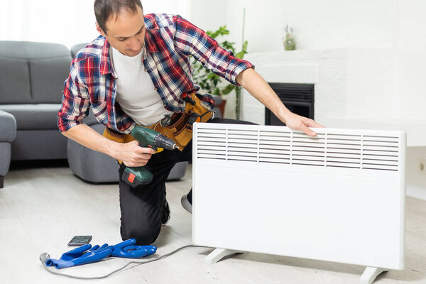 service man with wrench near radiator. High quality photo