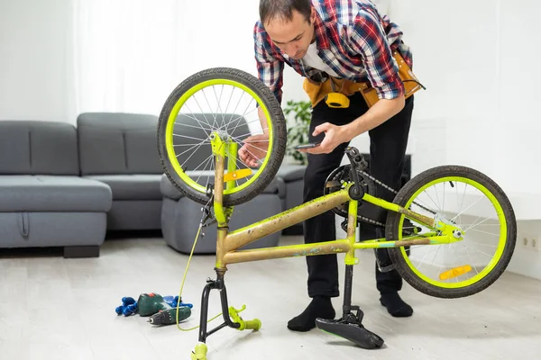 Male worker at the machine tool checks bicycle rim. High quality photo