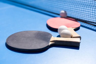 Spor kompozisyonu. Ping pong yakın plan. Mavi arkaplanda oynamak için raketler