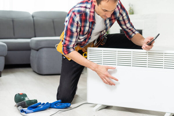 plumber at work. Installing water heating radiator. High quality photo