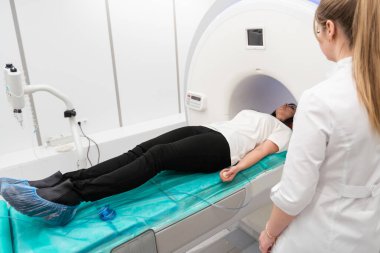 Modern hastane laboratuvarında tıbbi tomografi ya da MRI taraması. Radyografi bölümünün içi. Beyaz odada teknolojik olarak gelişmiş ekipmanlar var. Manyetik rezonans tanılama makinesi.