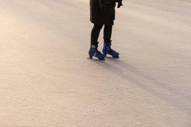 Buz pateni pistinde artistik paten giyen bir kadın, yakın plan. Metin için boşluk