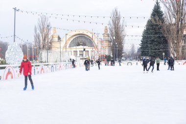 KYIV, UKRAINE - 23 Aralık 2022: buz pateni insanları. İnsanlar buz pateni sahasında eğleniyor. Kyiv 'de yeni yıl tatili. Kyiv Noel ve Yeni Yıl dekorasyonları