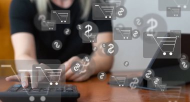 Çevrimiçi alışveriş ve e-ticaret kavramı. Alışveriş arabası simgesi olan dizüstü bilgisayar kullanan genç bir kadın, çevrimiçi mağazadan sipariş veren, internetten alışveriş yapan, klavyede yazı yazan sanal ekranda konsept kullanan bir kadın.